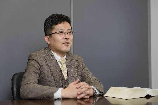 デスクに座り話をする福本弁護士